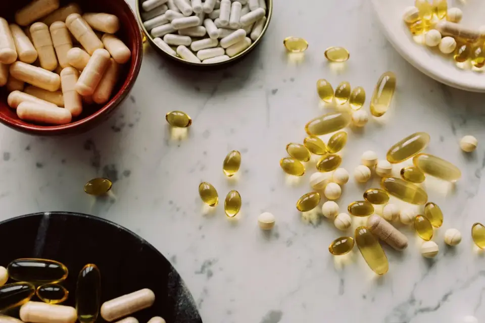 A bottle of fish oil softgel supplements set beside a dog&#x27;s food bowl