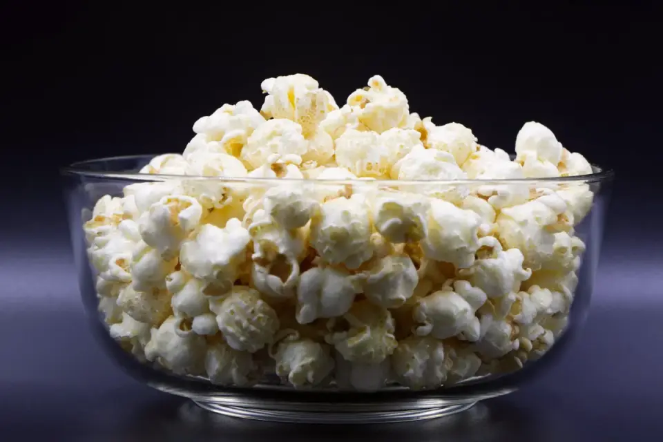 A small bowl of unpopped popcorn kernels on a kitchen counter