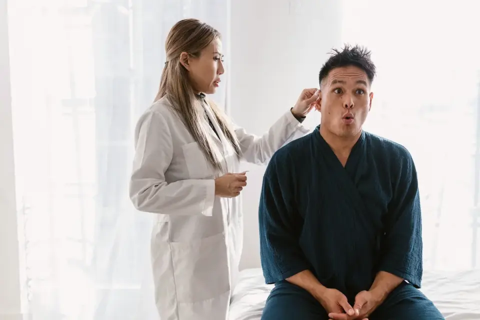 A veterinarian gently examining a dog&#x27;s ear canal with an otoscope