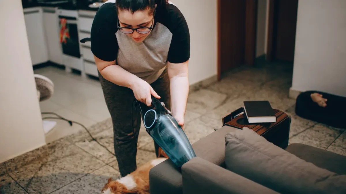 A woman reads the ingredient panel on a supplement bottle while her dog sits nearby